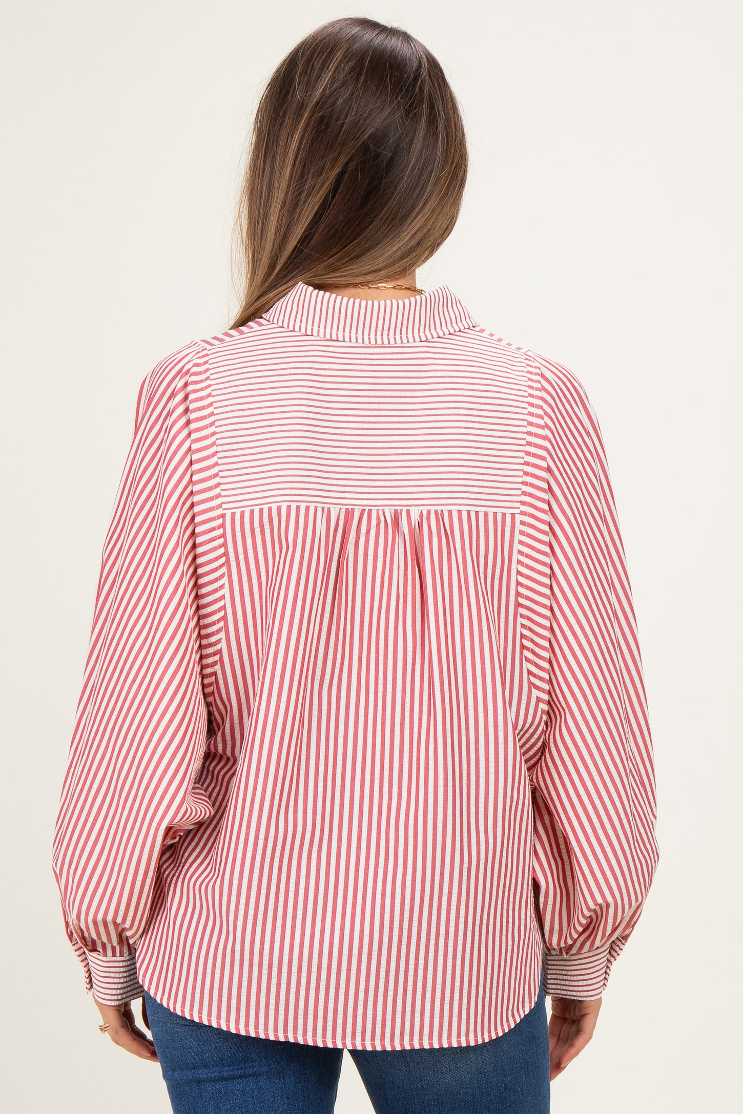woman wearing a red and white striped maternity blouse with a relaxed fit and back pleating detail