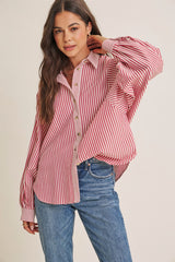woman wearing a red and white striped oversized button-up shirt with balloon sleeves and blue jeans