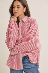 woman wearing a red and white striped oversized button-up shirt with long sleeves and relaxed fit