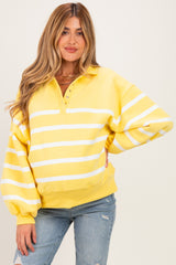 woman wearing a yellow and white striped maternity pullover with a button-up collar and relaxed fit