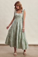 woman wearing a green and white striped maxi dress with tie straps and tiered skirt