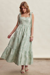 woman wearing a green and white striped maxi dress with tie straps and tiered skirt