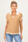 woman wearing a beige maternity polo shirt with a white collar and striped hem, styled with blue jeans