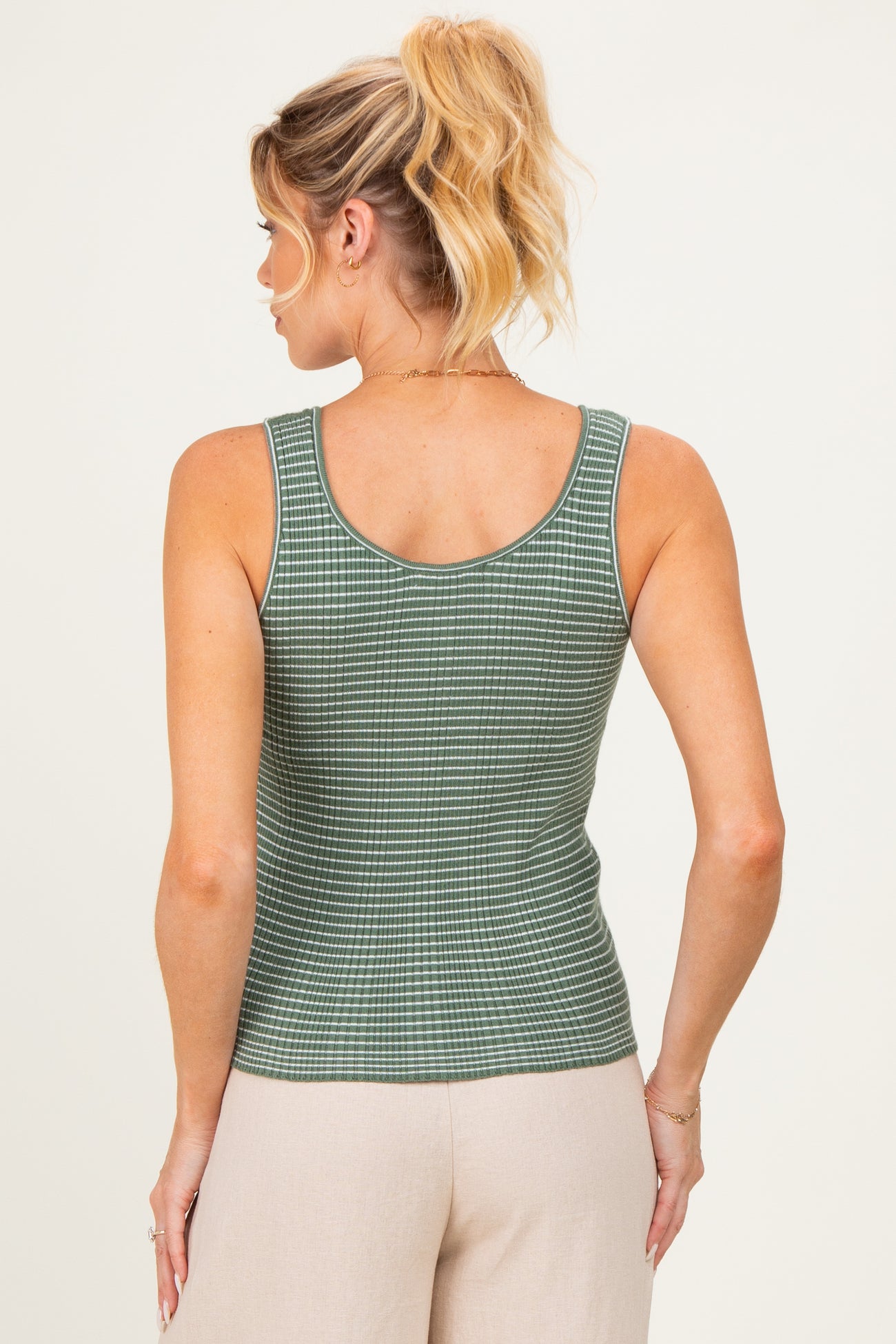 woman wearing a green and white checkered maternity tank top, seen from the back