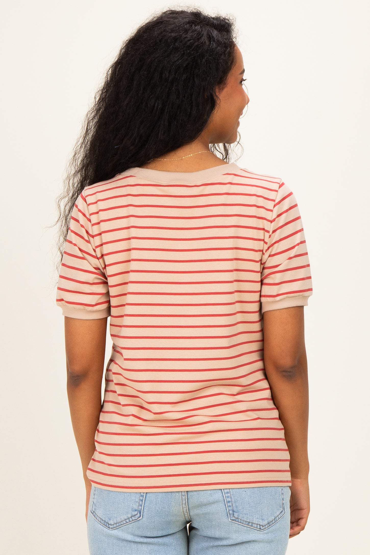 woman wearing a beige and red striped maternity t-shirt, showing the back with short sleeves and curved hem