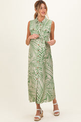woman wearing a green palm leaf print maternity maxi dress with a fitted bodice and button-down front, holding her baby bump