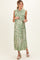 woman wearing a green palm leaf print maternity maxi dress with a fitted bodice and button-down front, holding her baby bump