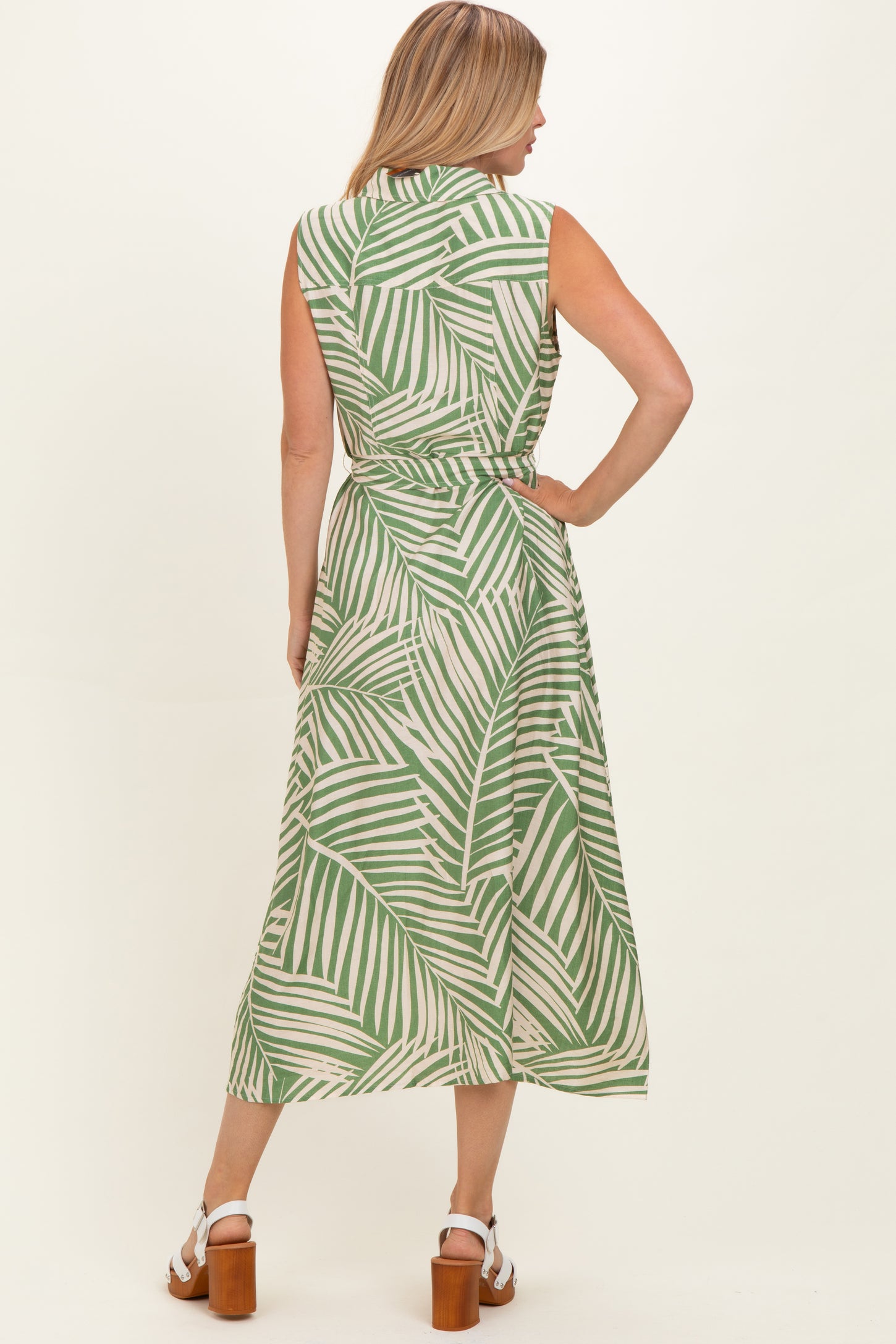 woman wearing a green and white leaf print sleeveless maxi dress, shown from the back