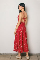 woman wearing a red polka dot maxi dress with a tie-back detail and a flowy silhouette