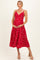 woman wearing a red polka dot maternity dress and holding her baby bump