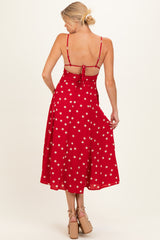 woman wearing a red polka dot maternity dress with a tie-back detail and flowy skirt