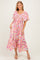 woman wearing a pink floral maxi dress with ruffled sleeves and a smocked bodice
