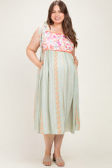 woman wearing a floral print maternity plus maxi dress with ruffled straps and side pockets, featuring a striped pattern and a baby bump