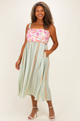 woman wearing a floral and striped plus size sundress with pockets and adjustable straps