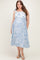 woman wearing a light blue maternity plus dress with floral print and tie straps, featuring a flowy silhouette and a baby bump