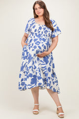 woman wearing a blue and white floral short sleeve maternity dress with a smocked bodice and a visible baby bump