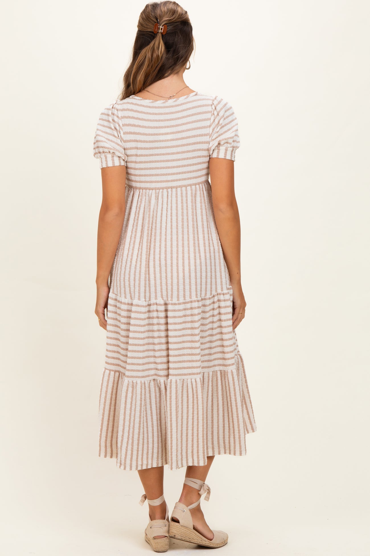 woman wearing a striped short sleeve maternity maxi dress with a tiered skirt and back view displayed