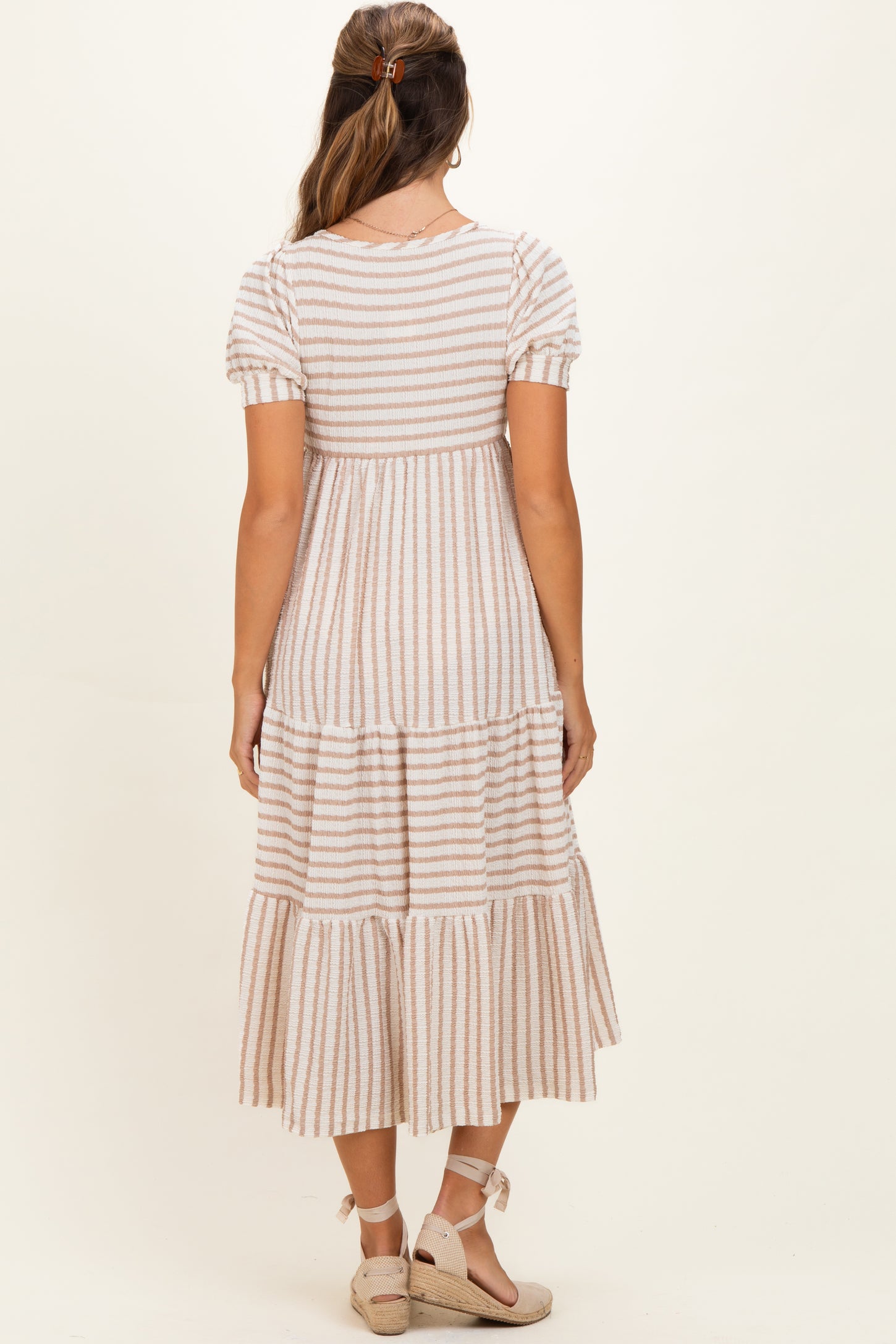 woman wearing a striped short sleeve maternity maxi dress with a tiered skirt and back view displayed