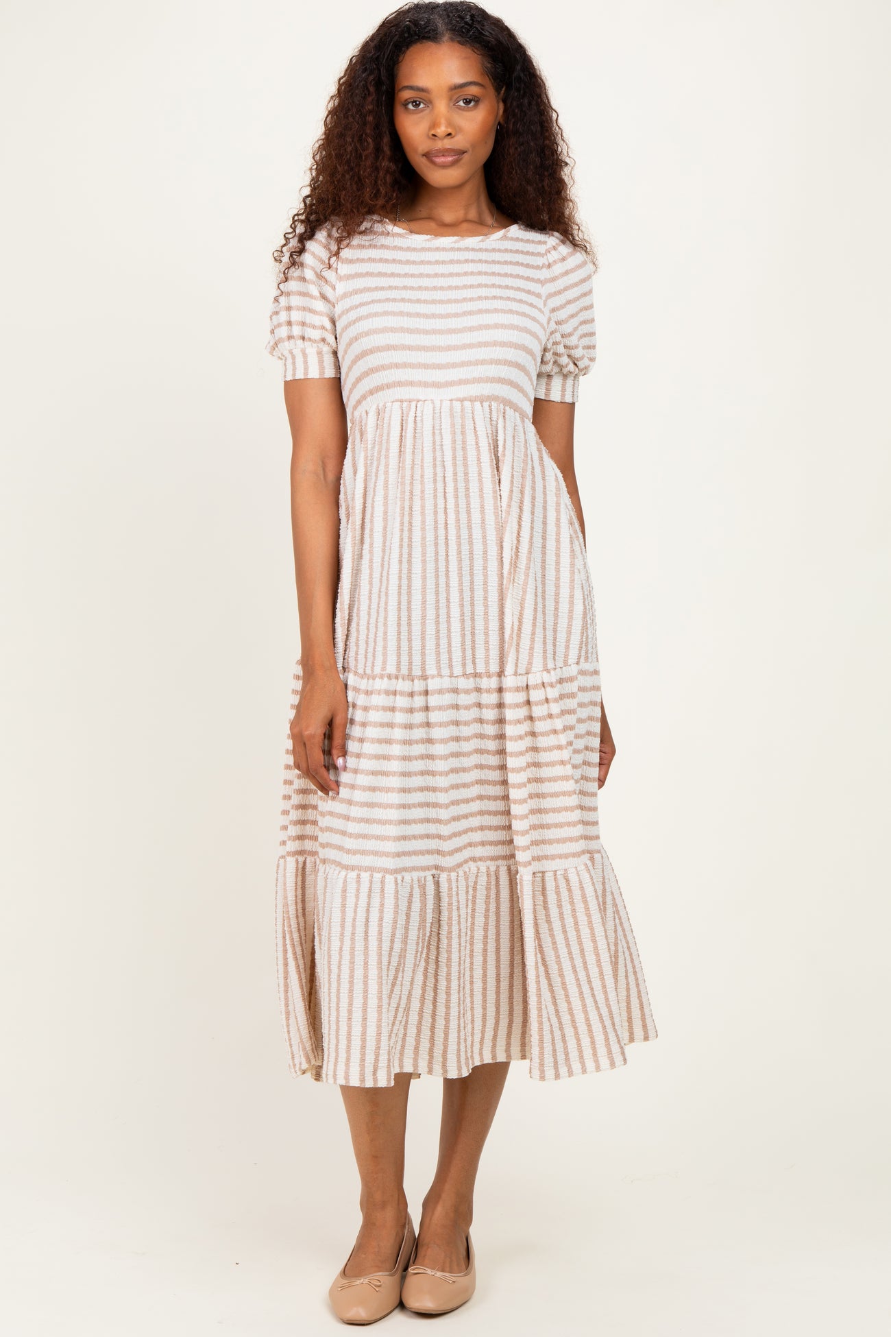woman wearing a striped short sleeve midi dress with tiered ruffle hem and round neckline