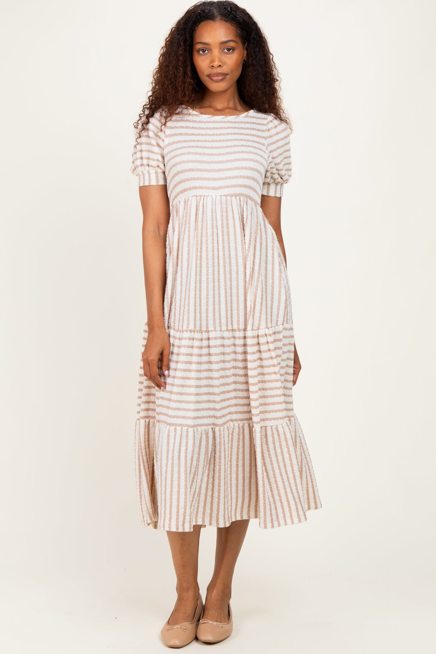 woman wearing a striped short sleeve midi dress with tiered ruffle hem and round neckline