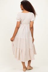 woman wearing a white and striped maxi dress with short sleeves and tiered ruffles, seen from the back
