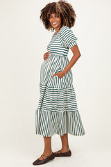 woman wearing a striped maternity maxi dress with short sleeves and pockets, highlighting her baby bump