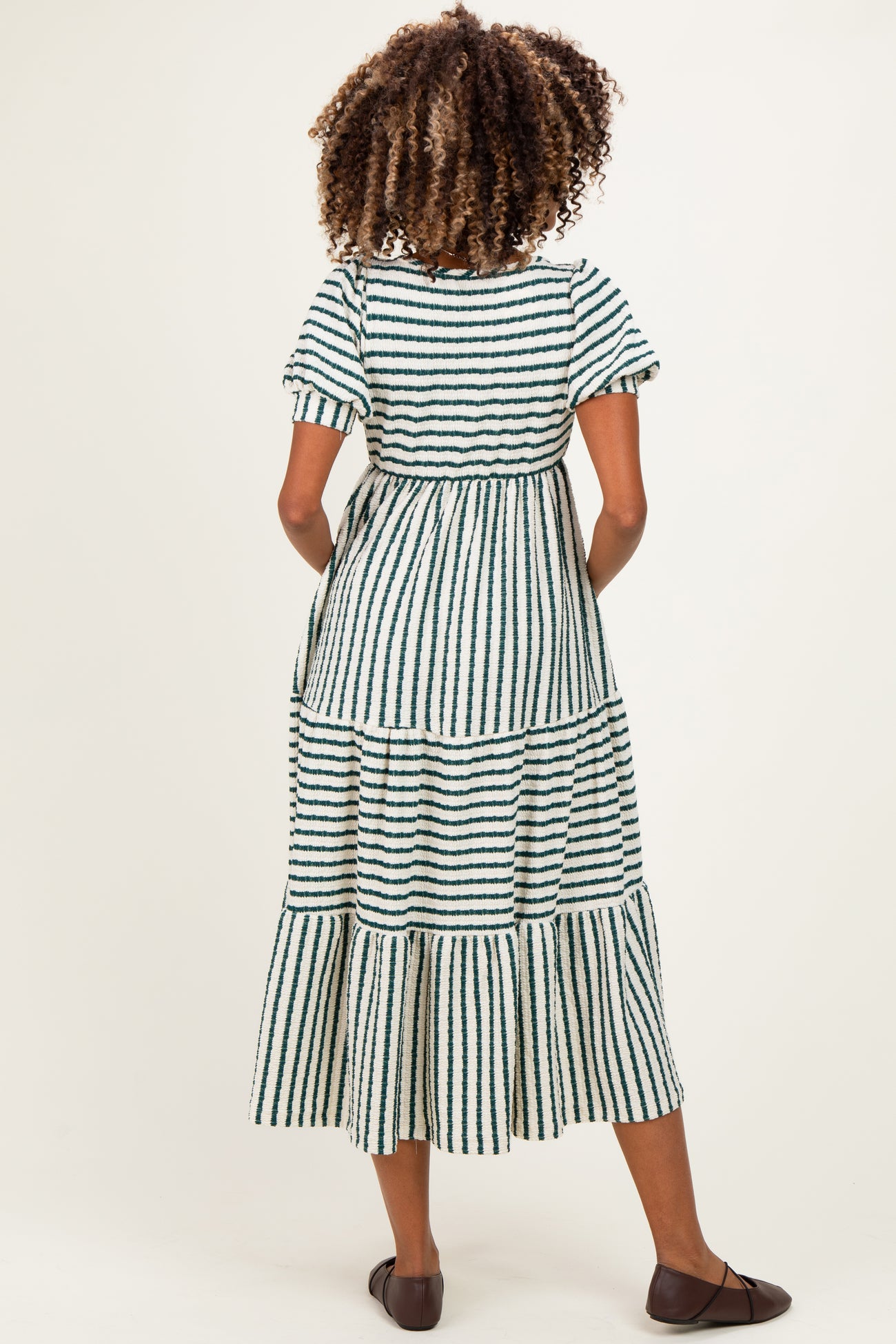 woman wearing a green and white striped maternity maxi dress with short sleeves and tiered ruffles