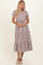 woman wearing a striped tiered midi dress with short puff sleeves and a flared hemline