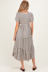 woman wearing a striped maternity dress with short sleeves and a tiered skirt, showing a relaxed fit