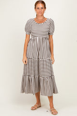 woman wearing a black and cream striped tiered midi dress with puff sleeves and a round neckline