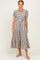 woman wearing a black and cream striped tiered midi dress with puff sleeves and a round neckline