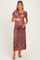 woman wearing a floral print maternity dress with short puff sleeves and a fitted bodice, cradling her baby bump