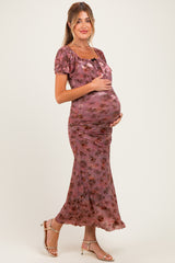 woman wearing a floral print pink maternity dress with a fitted silhouette and a visible baby bump