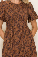 woman wearing a brown floral print dress with short puff sleeves and a fitted waist
