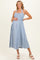 woman wearing a light blue striped maternity dress with a smocked bodice and halter neck, holding her baby bump