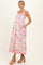 woman wearing a floral maternity maxi dress with a gathered waist and pockets, showcasing her baby bump