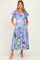 woman wearing a light blue floral maternity dress with short puff sleeves and pockets, showcasing her baby bump