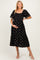 woman wearing a black maternity dress with gold patterns and short sleeves, gently cradling her baby bump