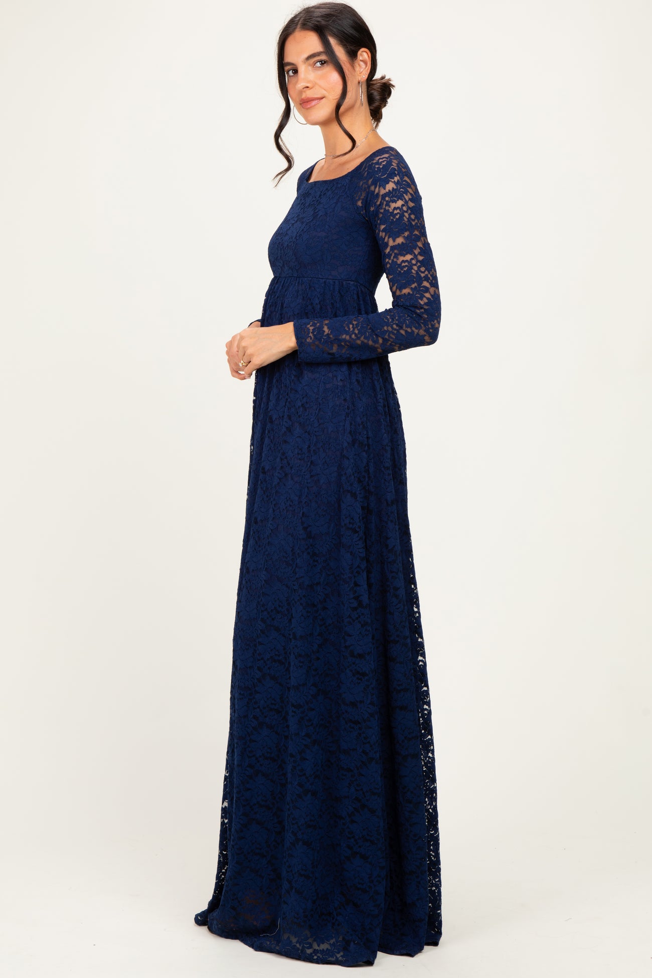 woman wearing a navy blue lace long sleeve maxi dress standing in profile