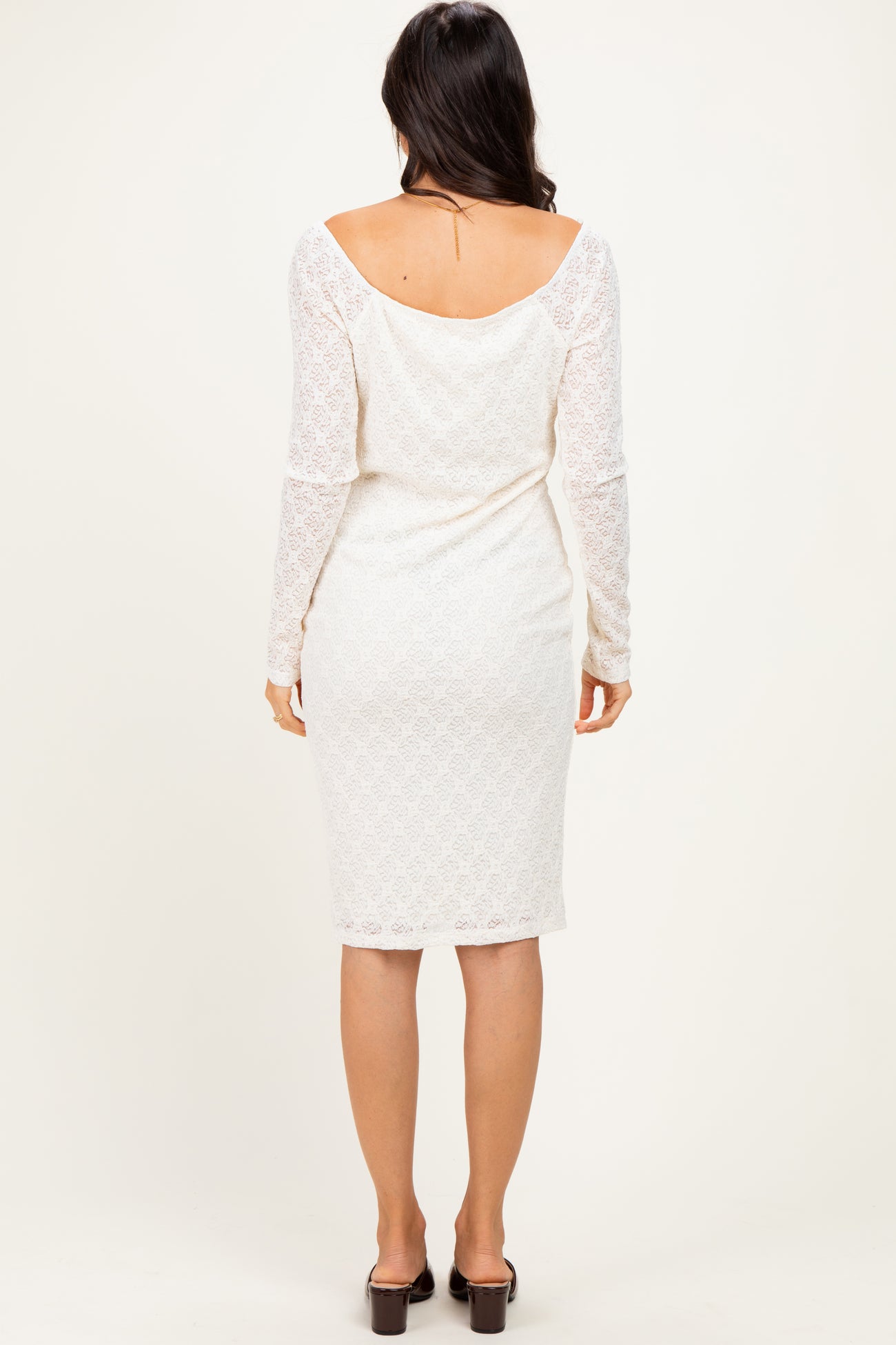 woman wearing a white lace long sleeve midi dress, showcased from the back with a fitted silhouette