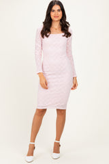 woman wearing a light pink long sleeve lace bodycon dress with a square neckline and white heels