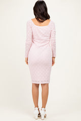 woman wearing a light pink long sleeve lace bodycon dress, view from the back
