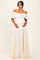 woman wearing a cream off-the-shoulder lace maternity maxi dress and cradling her baby bump