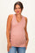 woman wearing a dusty pink v-neck maternity tank top accentuating her baby bump and paired with blue jeans