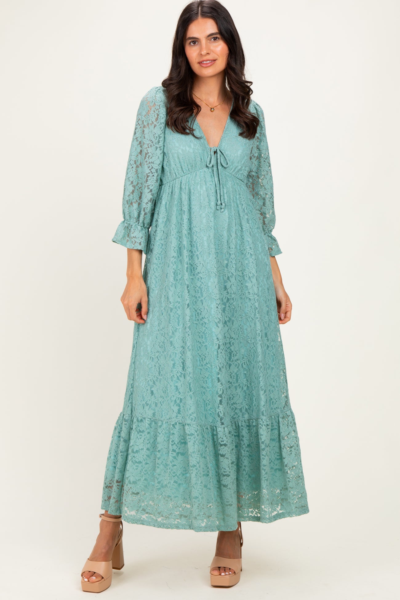 woman wearing a teal lace maxi dress with long sleeves and a tie-front detail