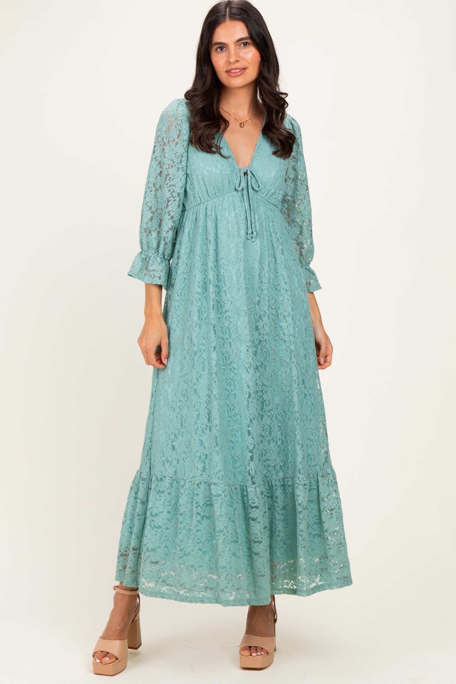 woman wearing a teal lace maxi dress with long sleeves and a tie-front detail