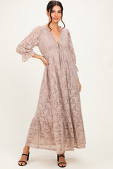 woman wearing a beige lace maxi dress with a deep v-neck and tie detail, styled with black high heel sandals
