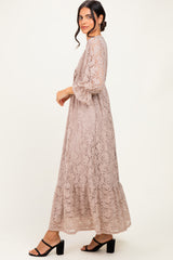 woman wearing a light taupe lace maxi dress with bell sleeves and tiered design, styled with black block heel sandals