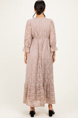 woman wearing a brown lace maxi dress with long sleeves and a ruffled hem, viewed from the back