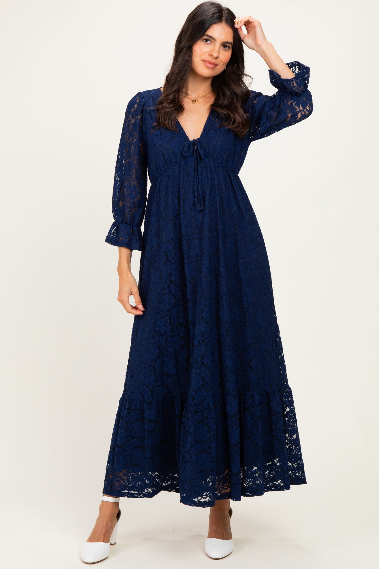 woman wearing a navy blue lace maxi dress with a tie front and bell sleeves